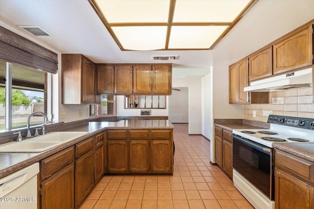 kitchen with light tile patterned flooring, a sink, white appliances, under cabinet range hood, and visible vents