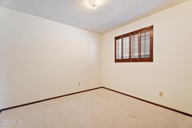carpeted empty room featuring baseboards and a textured ceiling