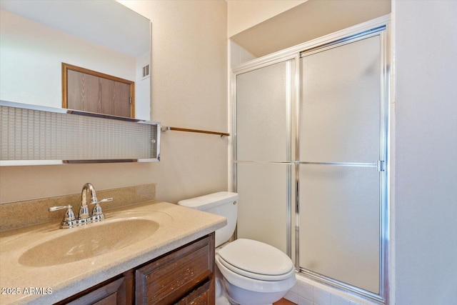 bathroom with vanity, a stall shower, and toilet