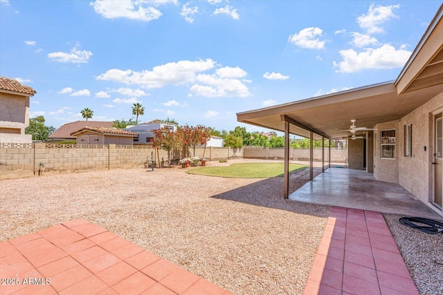 view of yard with a ceiling fan, a fenced backyard, and a patio area