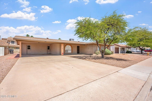 view of front of house with fence, a gate, concrete driveway, and an attached carport