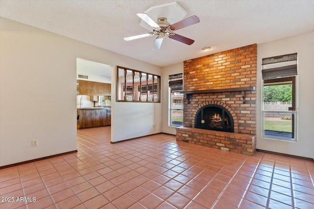 unfurnished living room with baseboards, tile patterned flooring, a textured ceiling, and visible vents