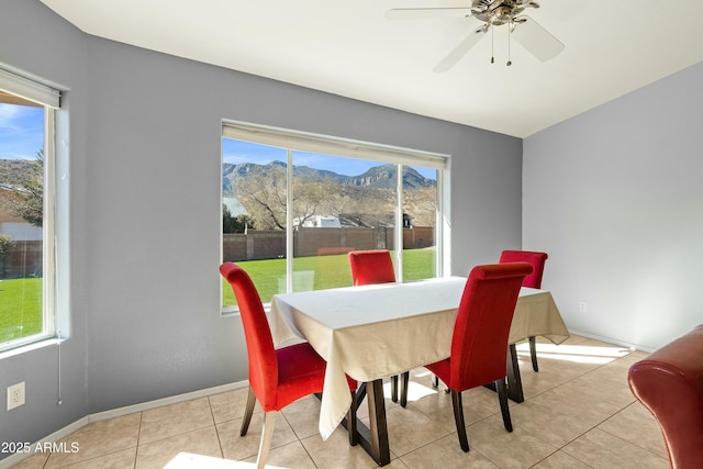 dining room featuring a mountain view, light tile patterned floors, and ceiling fan