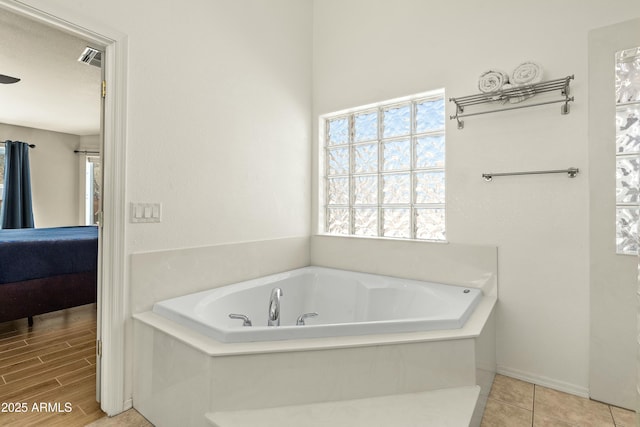 bathroom with tile patterned flooring and a bathing tub