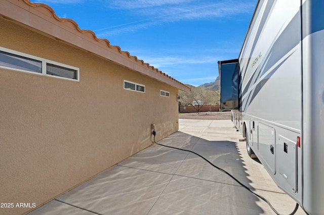 view of side of home with a mountain view and a patio area