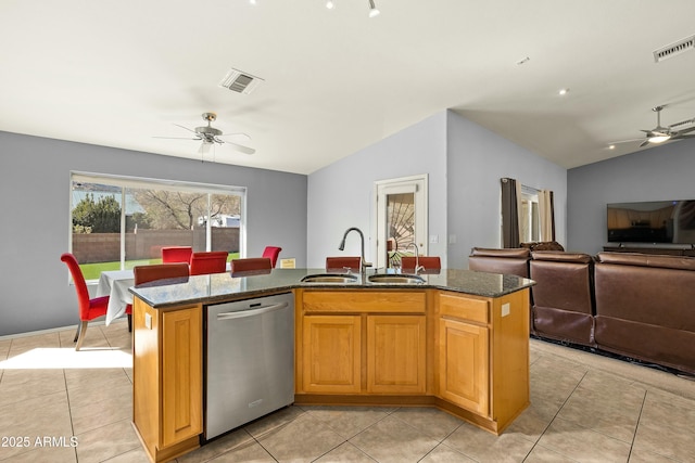 kitchen featuring dishwasher, lofted ceiling, a kitchen island with sink, and sink