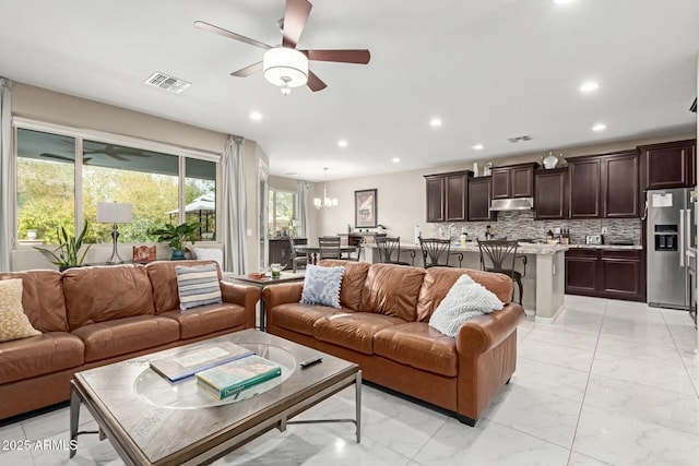 living room with recessed lighting, visible vents, marble finish floor, and ceiling fan with notable chandelier