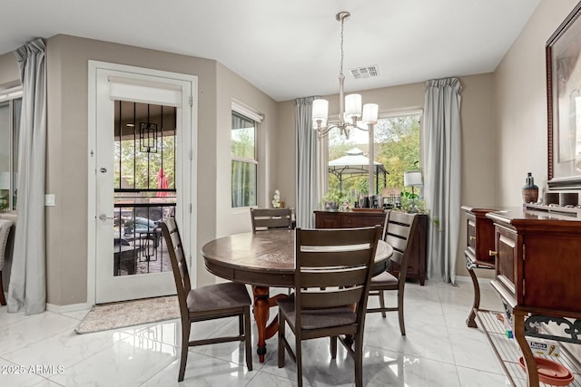 dining area featuring a chandelier, visible vents, marble finish floor, and baseboards