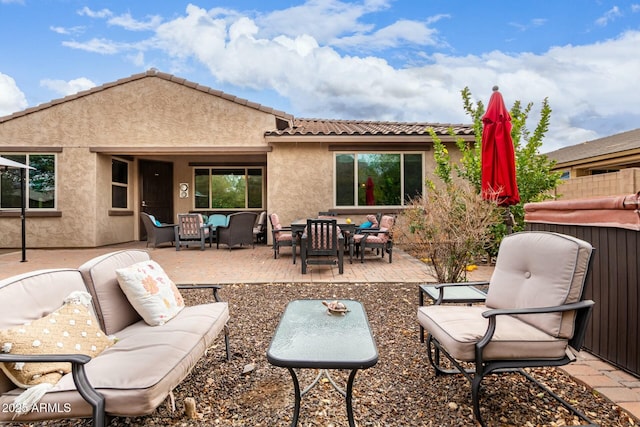 back of house with an outdoor living space, a patio area, and stucco siding