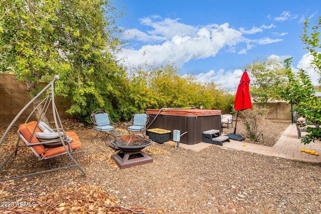 view of yard with a patio, a fenced backyard, a hot tub, and an outdoor fire pit