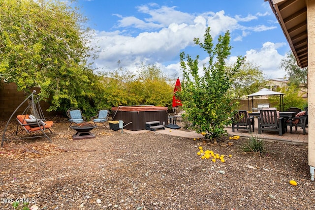 view of yard featuring a patio area, fence, a fire pit, and a hot tub