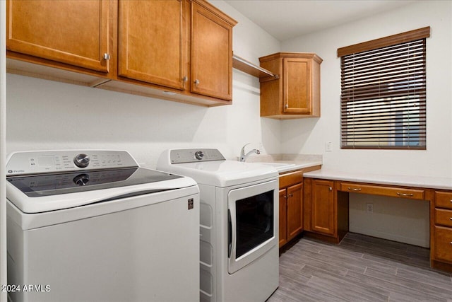 laundry room with cabinets, hardwood / wood-style flooring, separate washer and dryer, and sink