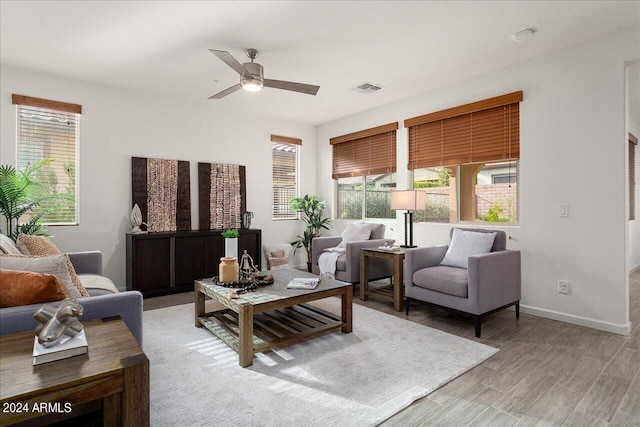 living room featuring ceiling fan, light hardwood / wood-style floors, and a healthy amount of sunlight