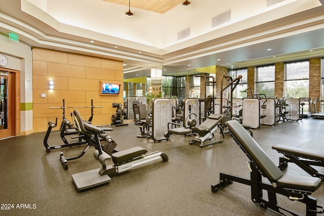 gym featuring a high ceiling and a tray ceiling