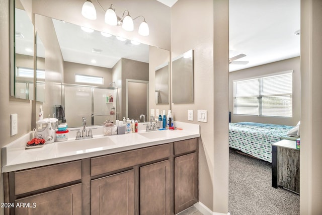 bathroom with ceiling fan, a shower with door, and vanity