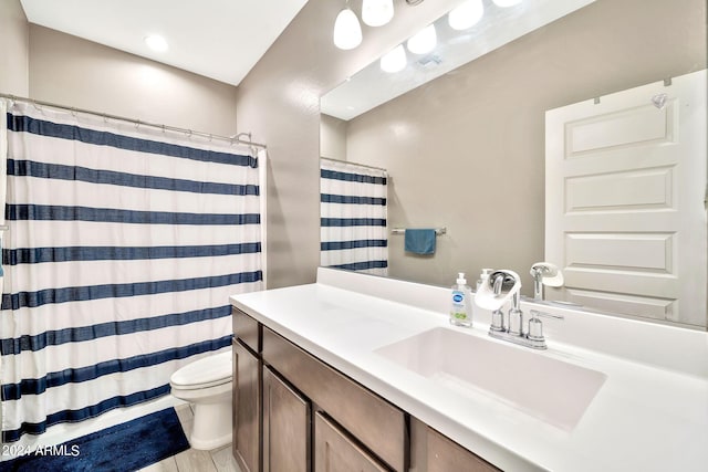 bathroom featuring curtained shower, vanity, and toilet