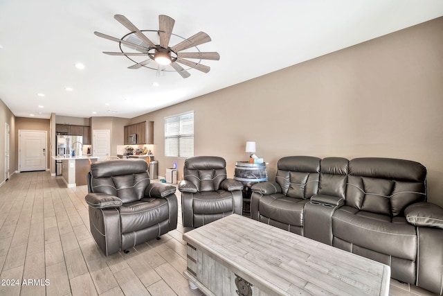 living room featuring ceiling fan and light hardwood / wood-style flooring