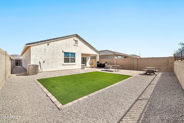 rear view of property featuring a patio and central AC