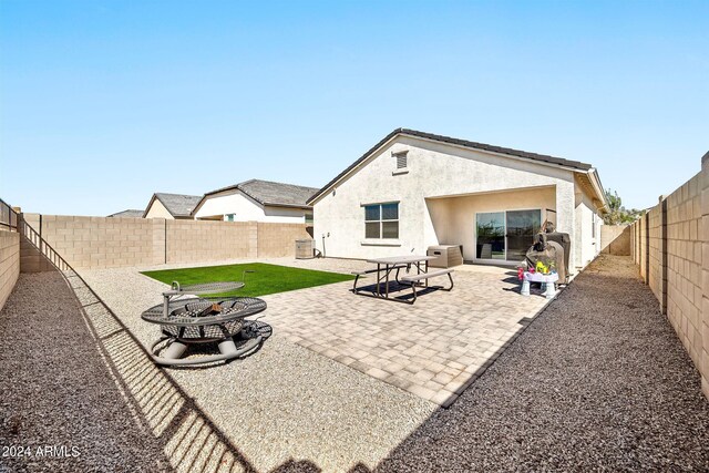 rear view of house with a patio area and a fire pit