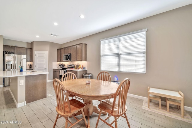 dining space with sink and light hardwood / wood-style flooring