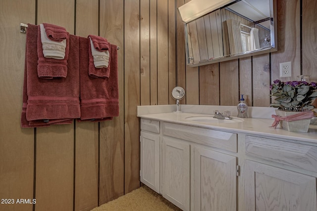 bathroom with vanity and wooden walls