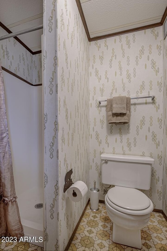 bathroom with toilet, a shower with curtain, ornamental molding, and a textured ceiling