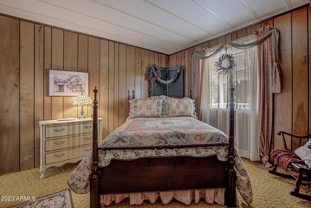 carpeted bedroom with wooden walls