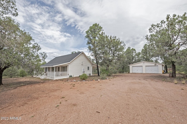 exterior space featuring covered porch, a garage, and an outbuilding