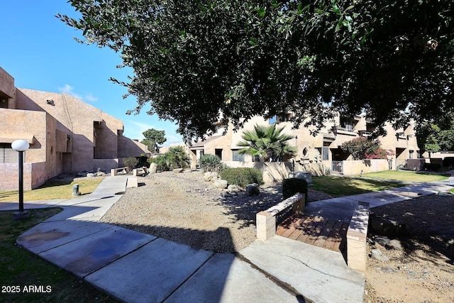 view of home's community featuring a patio, a residential view, fence, and a lawn