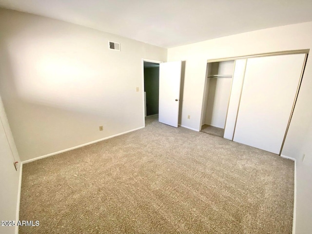 unfurnished bedroom with carpet, visible vents, a closet, and baseboards