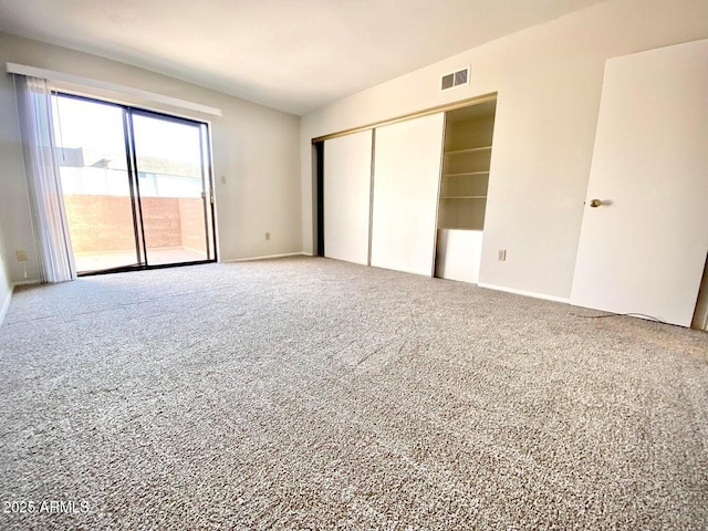 unfurnished bedroom with a closet, visible vents, access to exterior, carpet flooring, and baseboards