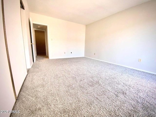 empty room featuring light colored carpet and baseboards