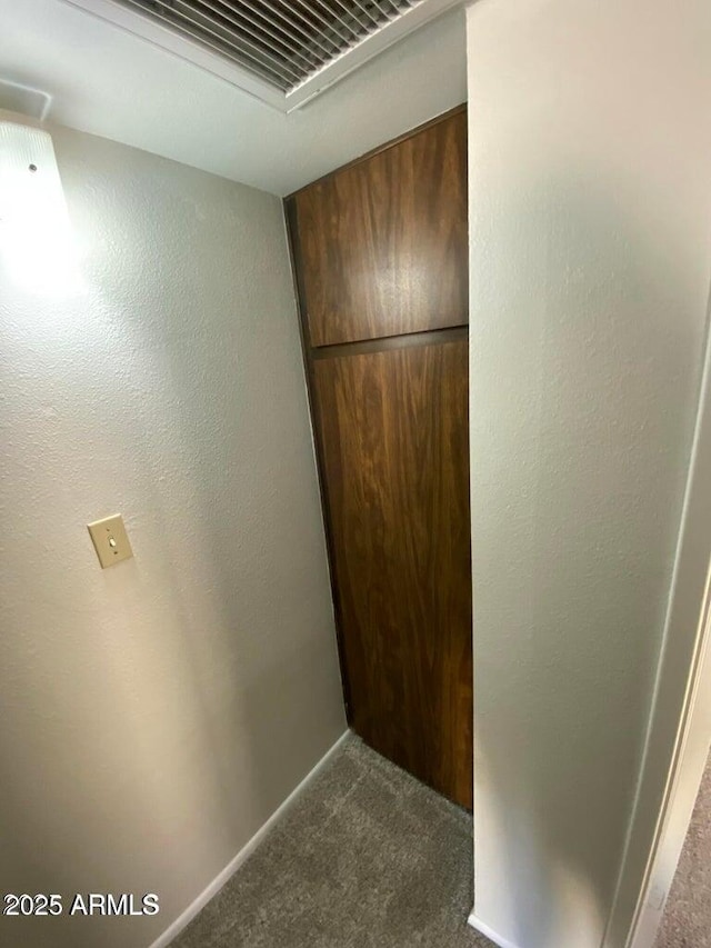interior space with dark carpet, baseboards, and visible vents