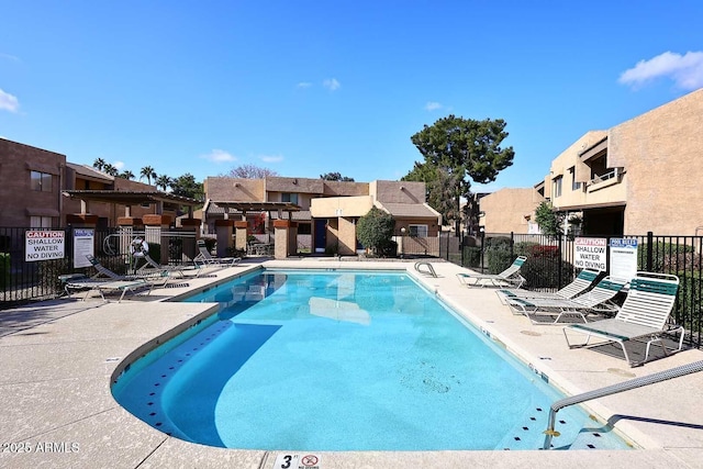 community pool featuring a patio, fence, and a residential view