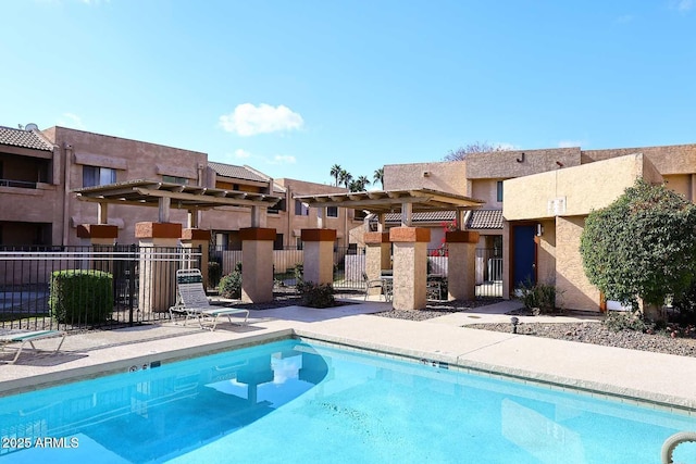 community pool with a residential view, a pergola, and fence
