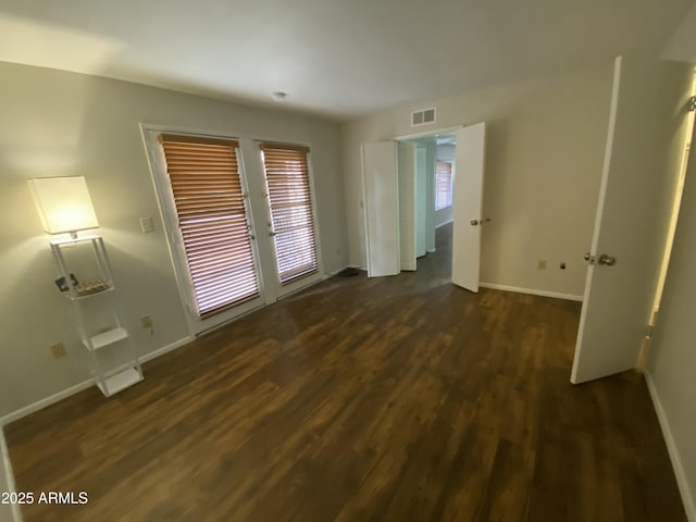 spare room with visible vents, baseboards, french doors, and dark wood-style floors