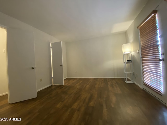 unfurnished room featuring baseboards and dark wood-style floors