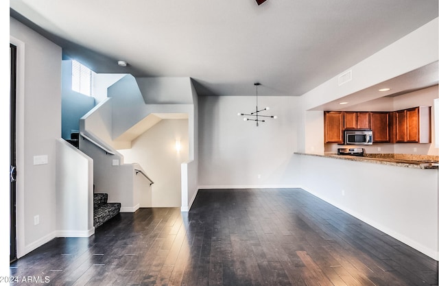 kitchen with dark wood-type flooring, stainless steel appliances, decorative light fixtures, and a notable chandelier