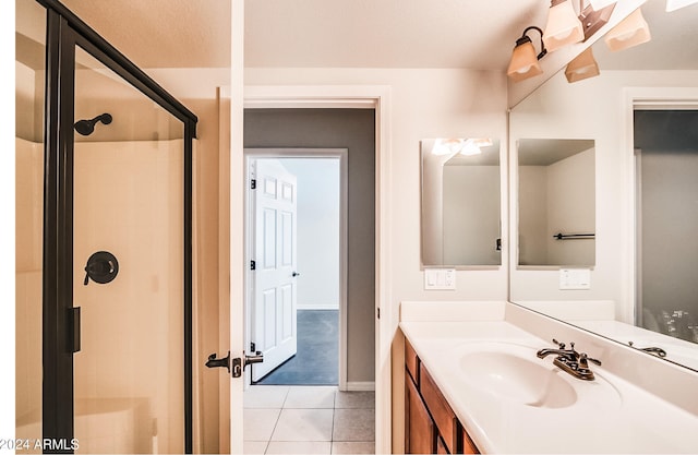 bathroom featuring tile patterned flooring, vanity, and an enclosed shower