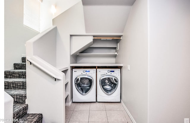 clothes washing area with washing machine and clothes dryer and light tile patterned floors