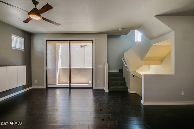 unfurnished living room with plenty of natural light, dark hardwood / wood-style floors, and ceiling fan