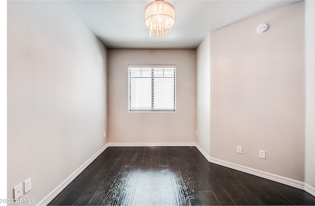 unfurnished room featuring hardwood / wood-style flooring and an inviting chandelier