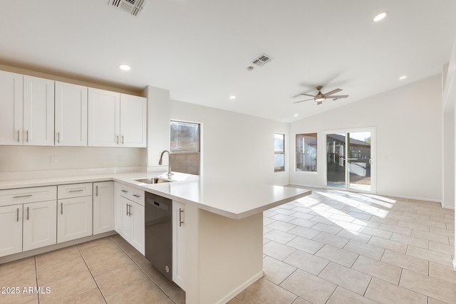 kitchen featuring black dishwasher, sink, white cabinets, and kitchen peninsula