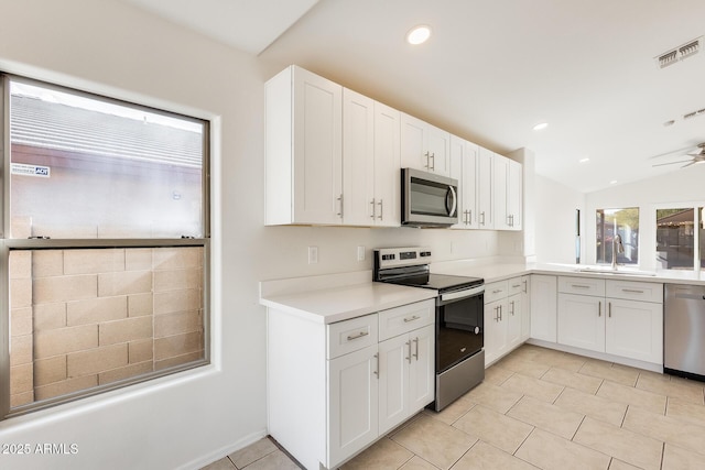 kitchen featuring sink, vaulted ceiling, white cabinets, and appliances with stainless steel finishes