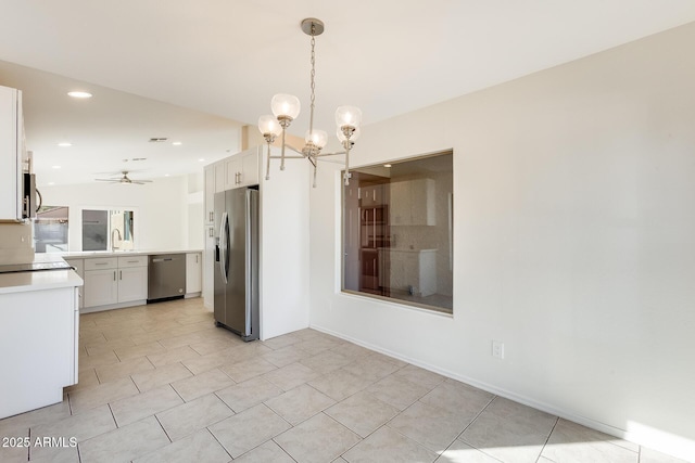 kitchen with white cabinetry, appliances with stainless steel finishes, decorative light fixtures, and sink