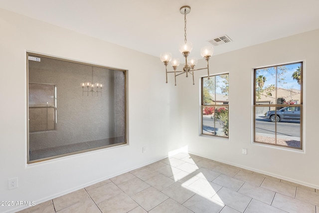 spare room with light tile patterned flooring and a notable chandelier