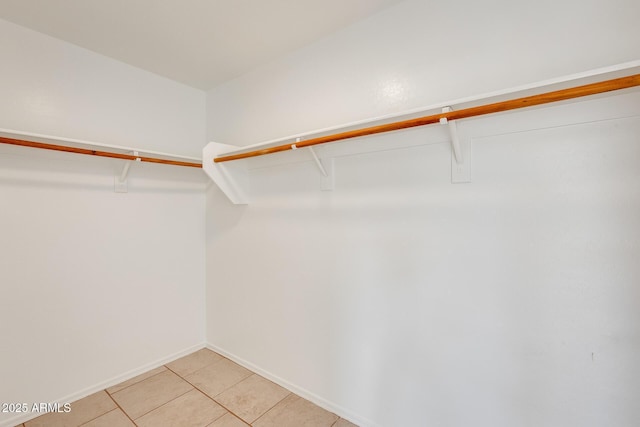 walk in closet with light tile patterned floors