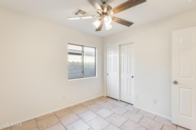 unfurnished bedroom featuring light tile patterned flooring, ceiling fan, and a closet