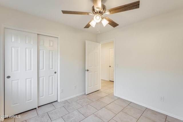 unfurnished bedroom with light tile patterned floors, a closet, and ceiling fan