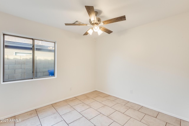 empty room with ceiling fan and light tile patterned floors